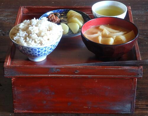 箱膳（はこぜん）の上にご飯茶わん、味噌汁、漬物、お茶、箸があります。